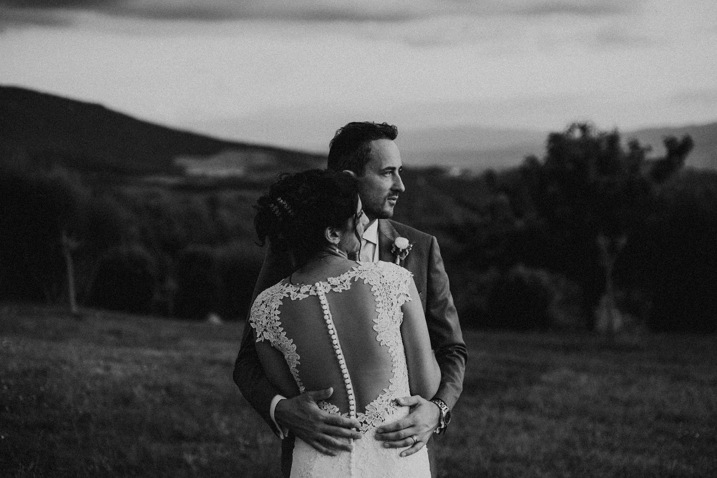 black and white photo of a couple hugging and looking the same direction
